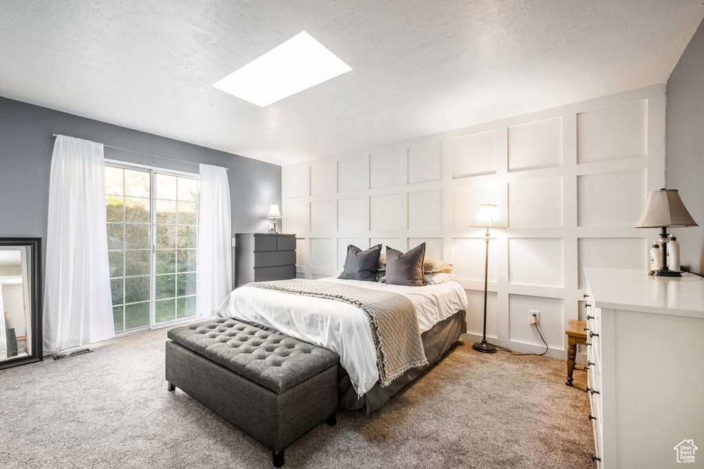 Bedroom featuring light colored carpet and a skylight