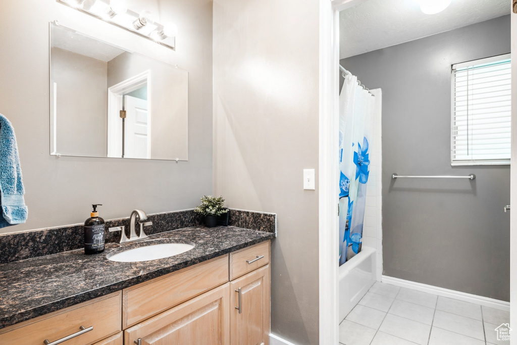 Bathroom with vanity, shower / bath combo, and tile floors