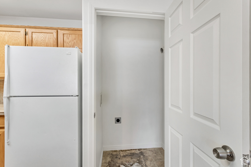 Interior space featuring light tile flooring and white fridge