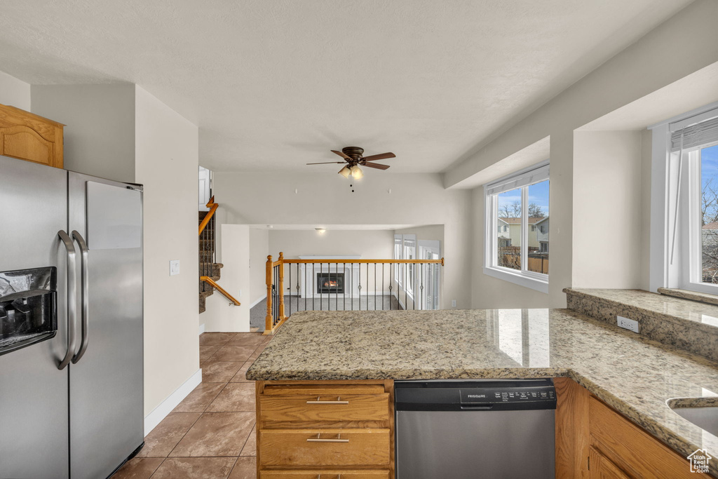 Kitchen featuring appliances with stainless steel finishes, light tile floors, plenty of natural light, and ceiling fan