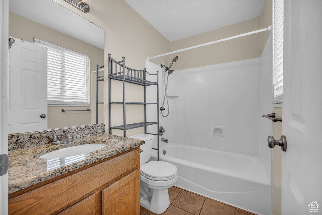 Full bathroom with shower / bath combination, toilet, tile flooring, and large vanity