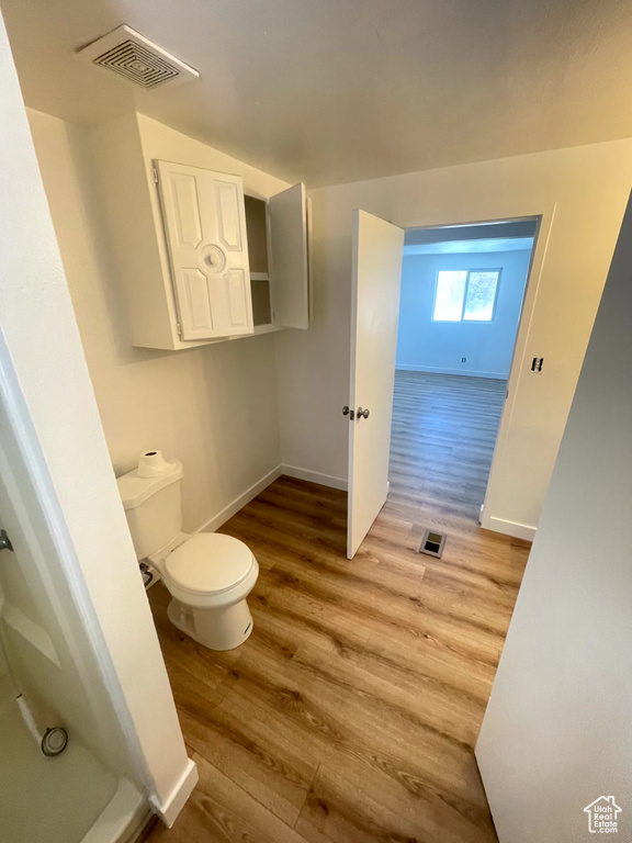 Bathroom featuring wood-type flooring and toilet