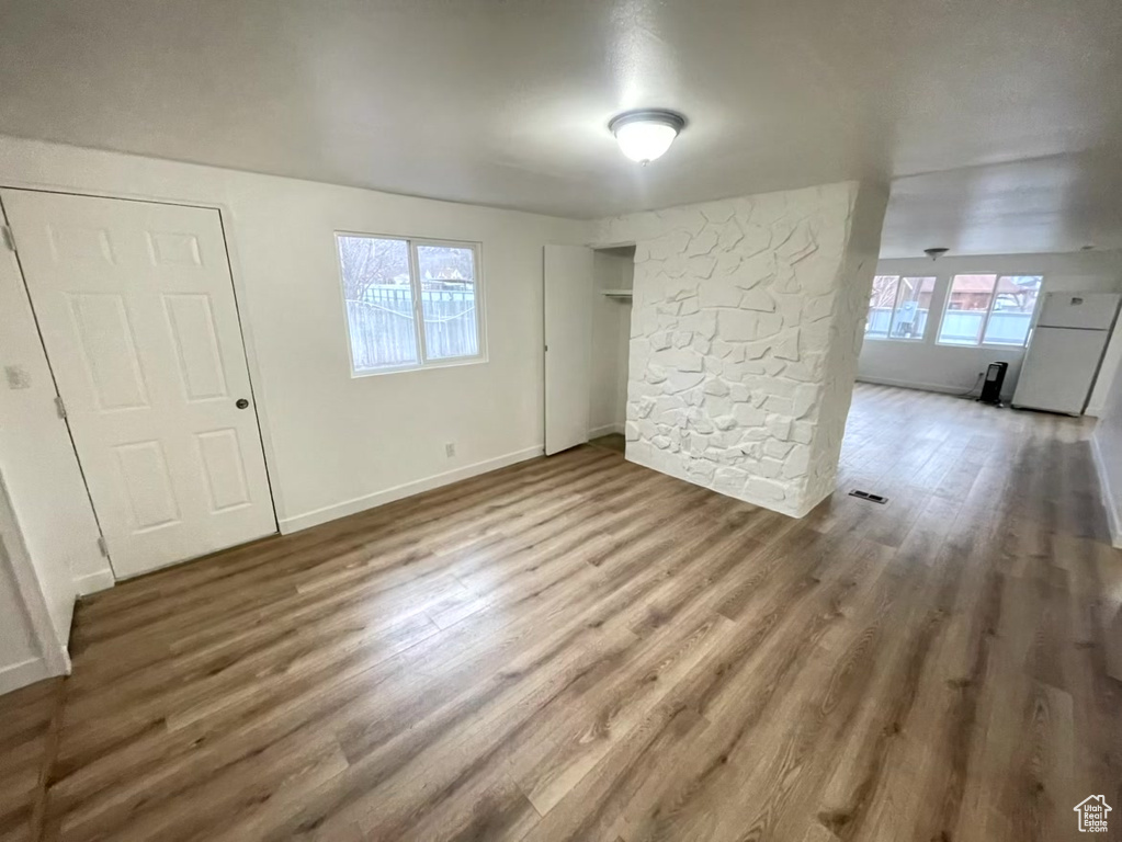 Spare room with wood-type flooring and a healthy amount of sunlight