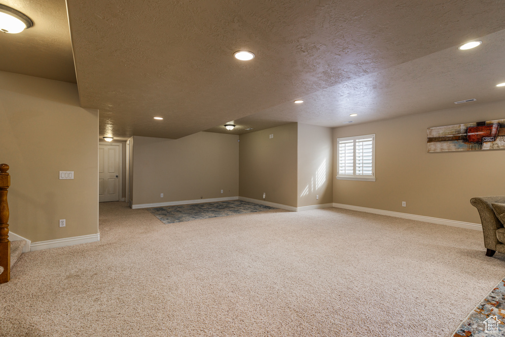 Interior space with a textured ceiling and light carpet