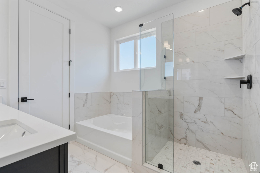 Bathroom with vanity, tile patterned flooring, and shower with separate bathtub