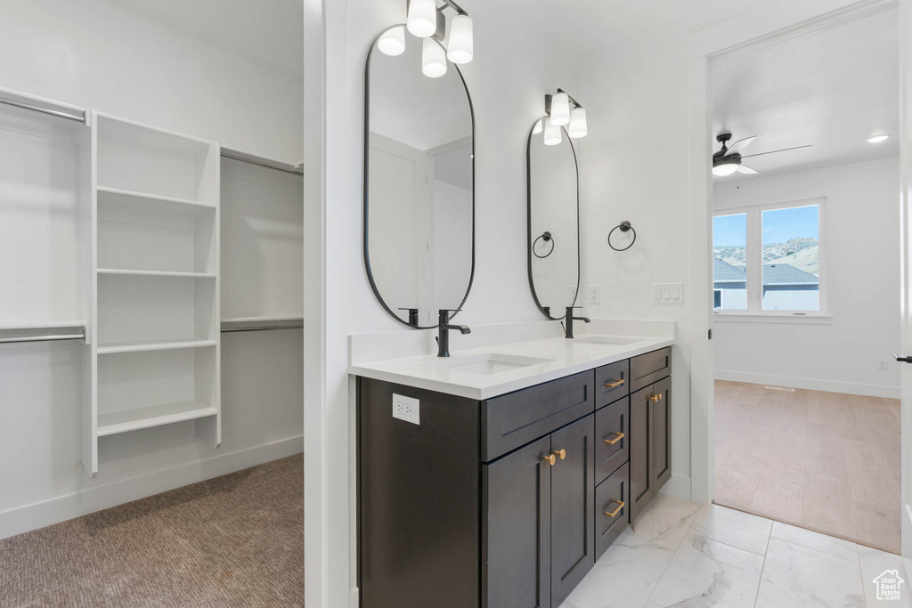 Bathroom with ceiling fan, wood-type flooring, and dual bowl vanity