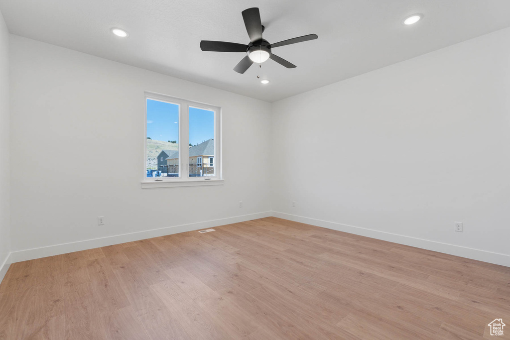Unfurnished room with light hardwood / wood-style floors and ceiling fan