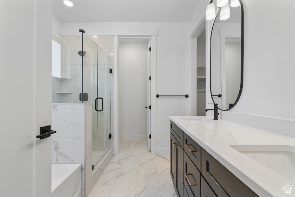 Bathroom with a shower with shower door, tile patterned floors, and double sink vanity