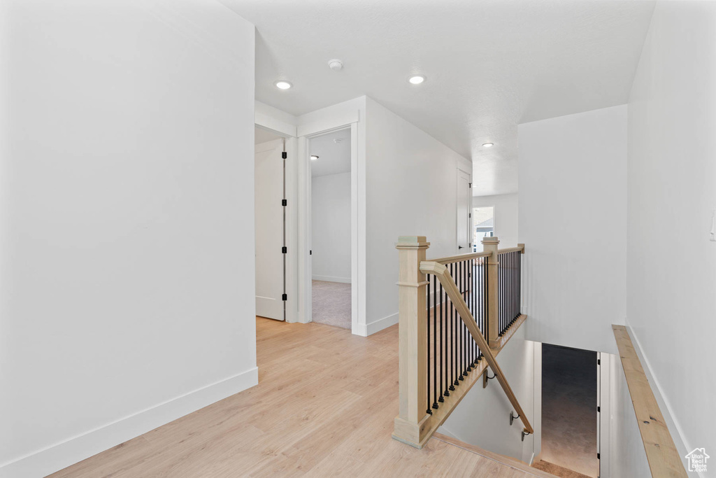Corridor with light hardwood / wood-style flooring