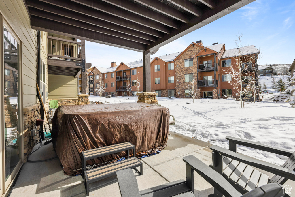 Snow covered patio featuring a balcony