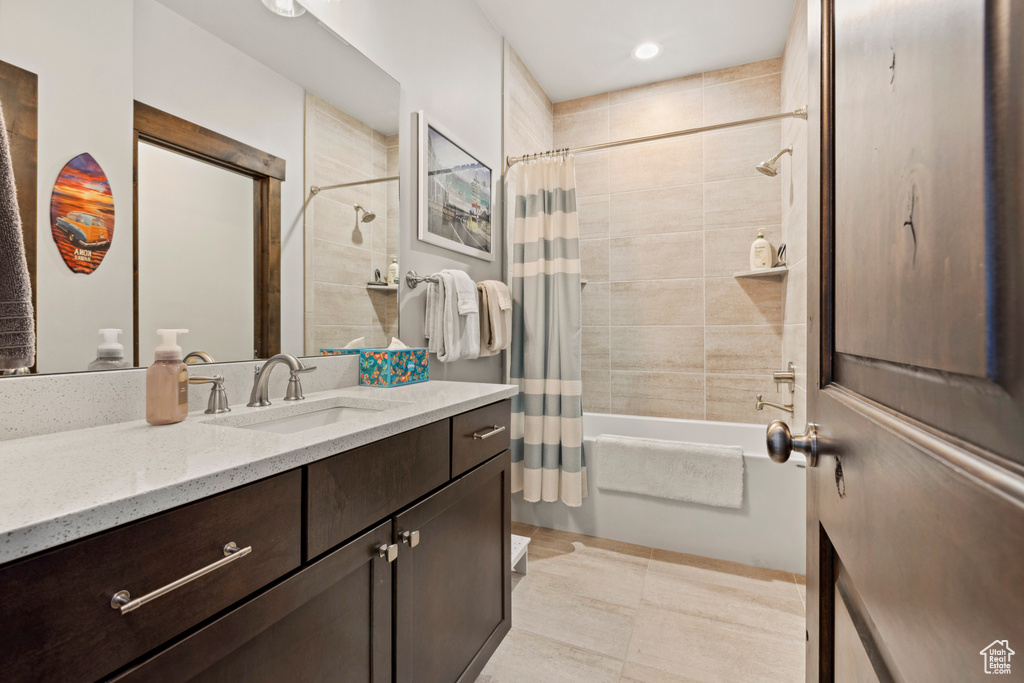 Bathroom with vanity, shower / bathtub combination with curtain, and tile floors