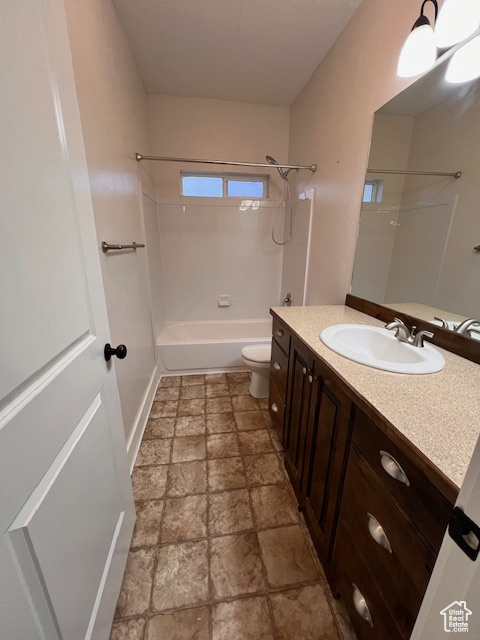 Full bathroom with vanity, toilet, tile flooring, and washtub / shower combination