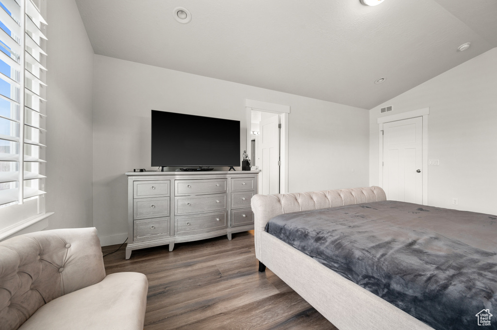 Bedroom featuring vaulted ceiling and dark hardwood / wood-style flooring