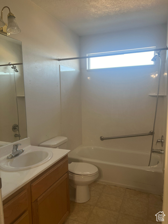 Full bathroom with vanity, toilet, a textured ceiling, and shower / tub combination