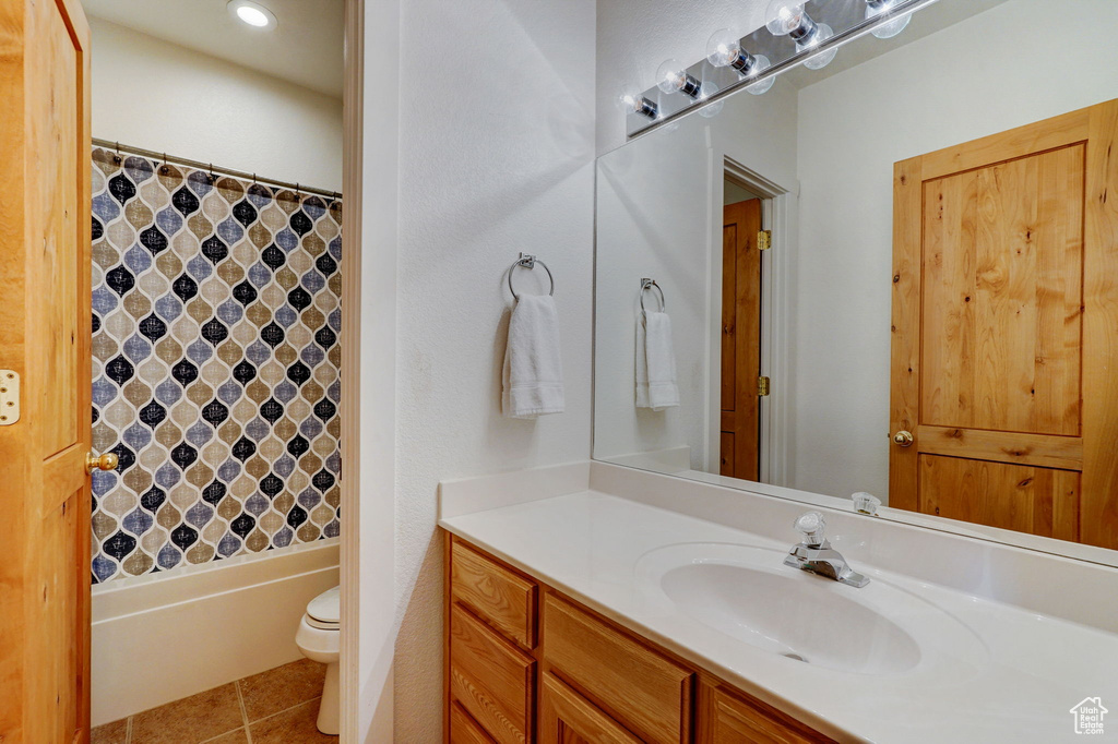 Full bathroom featuring tile floors, toilet, shower / bath combo, and oversized vanity