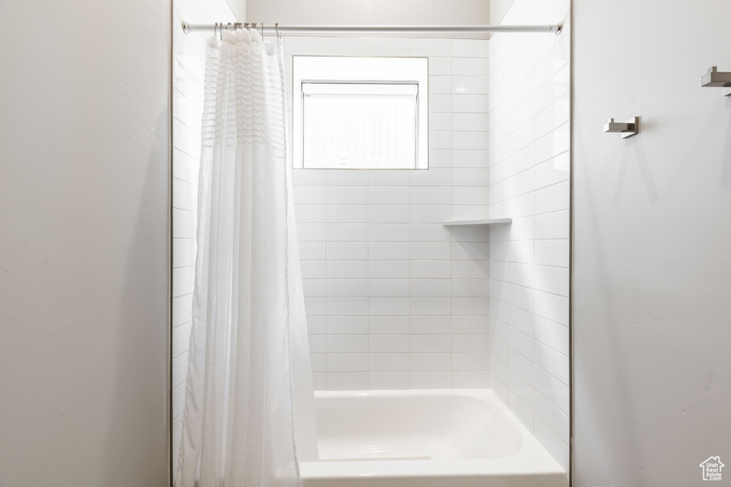 Bathroom featuring shower / bathtub combination with curtain