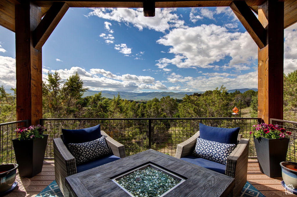 Wooden terrace featuring a mountain view and a fire pit