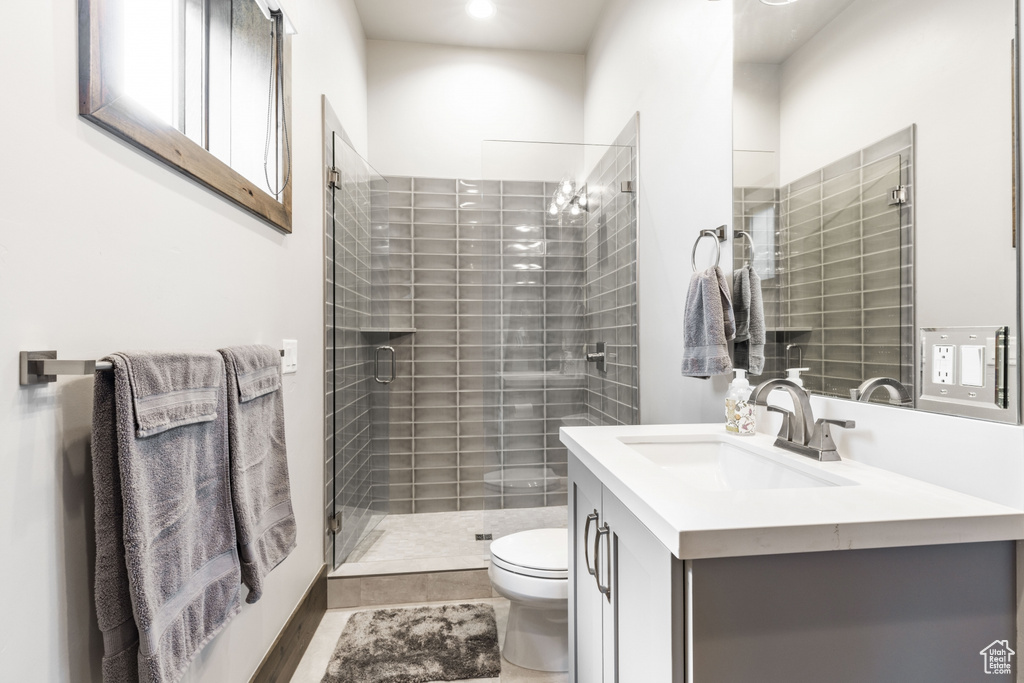 Bathroom featuring vanity, a chandelier, toilet, tile floors, and a shower with shower door