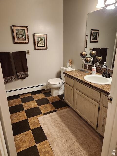 Bathroom with vanity, toilet, tile flooring, and a baseboard heating unit
