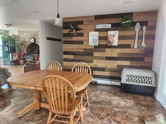 Tiled dining room with wooden walls and brick wall