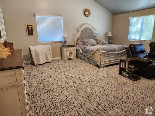 Bedroom with lofted ceiling and light colored carpet
