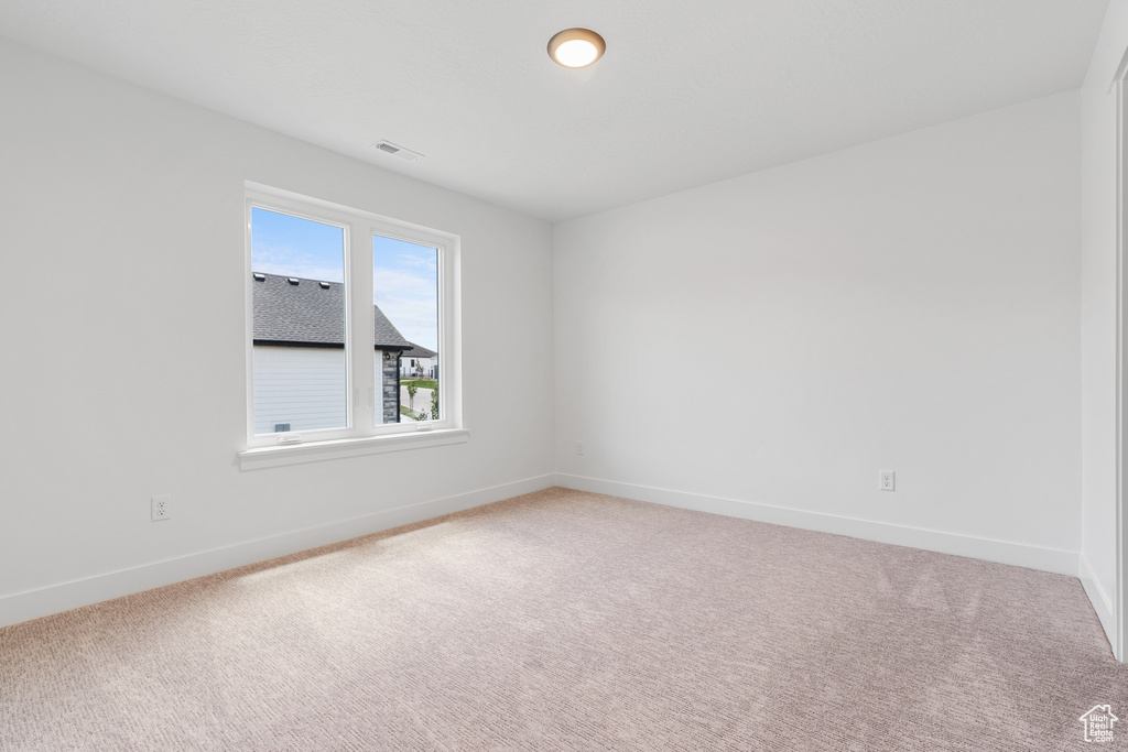 Empty room featuring light colored carpet