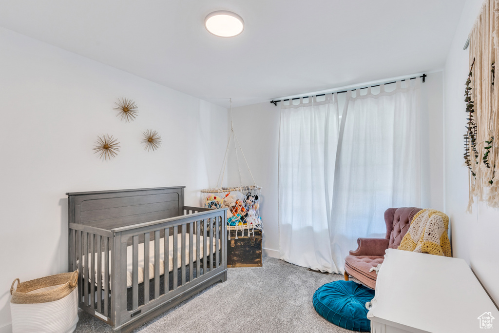 Bedroom with light colored carpet and a nursery area