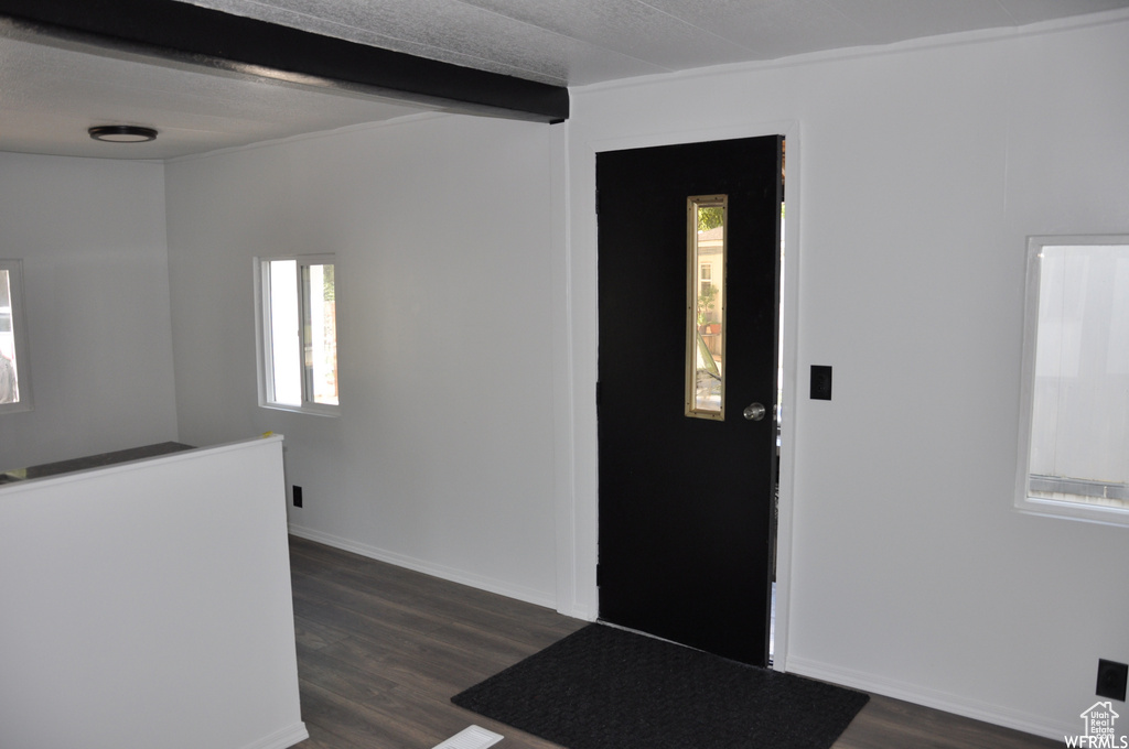 Entryway featuring dark hardwood / wood-style flooring and beam ceiling