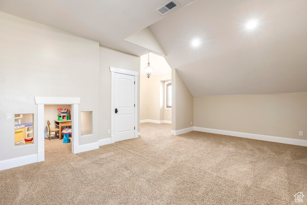 Bonus room featuring light colored carpet and lofted ceiling