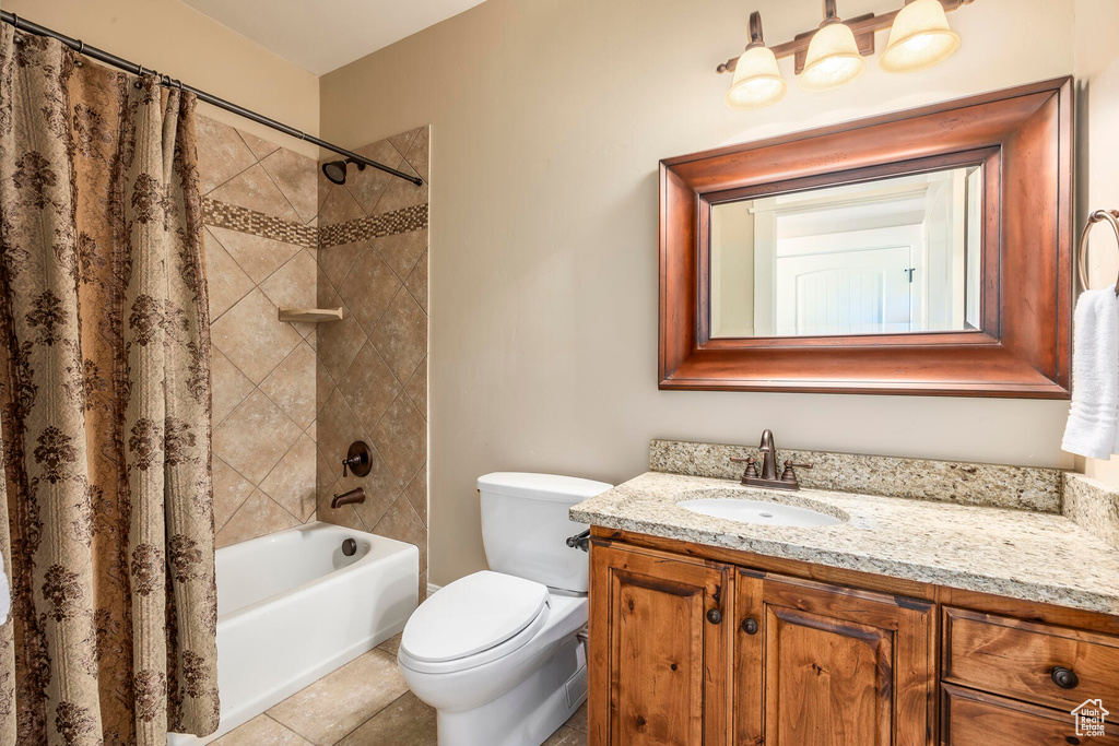 Full bathroom with tile patterned flooring, toilet, vanity, and shower / tub combo