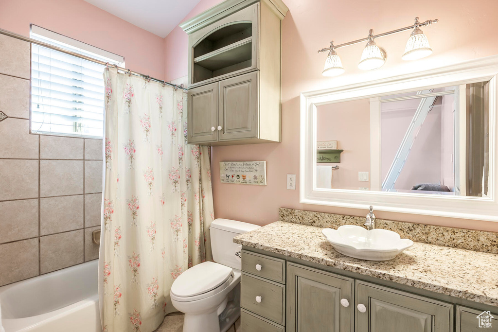 Full bathroom with shower / bath combination with curtain, vanity, and toilet