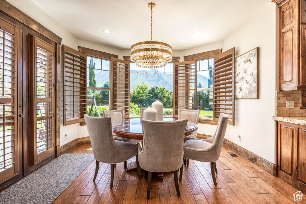 Dining area with light wood-type flooring and a notable chandelier