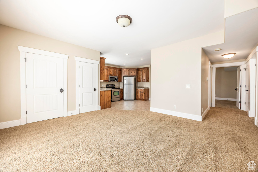 Unfurnished living room featuring light carpet