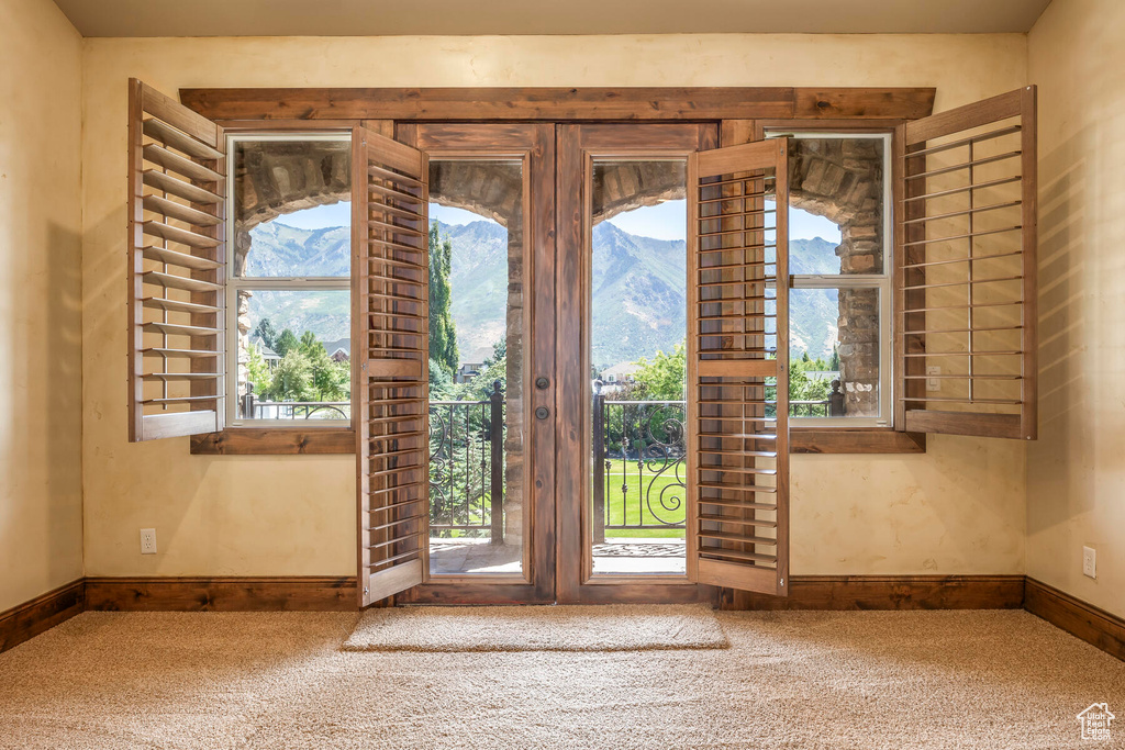 Doorway to outside featuring a mountain view and carpet