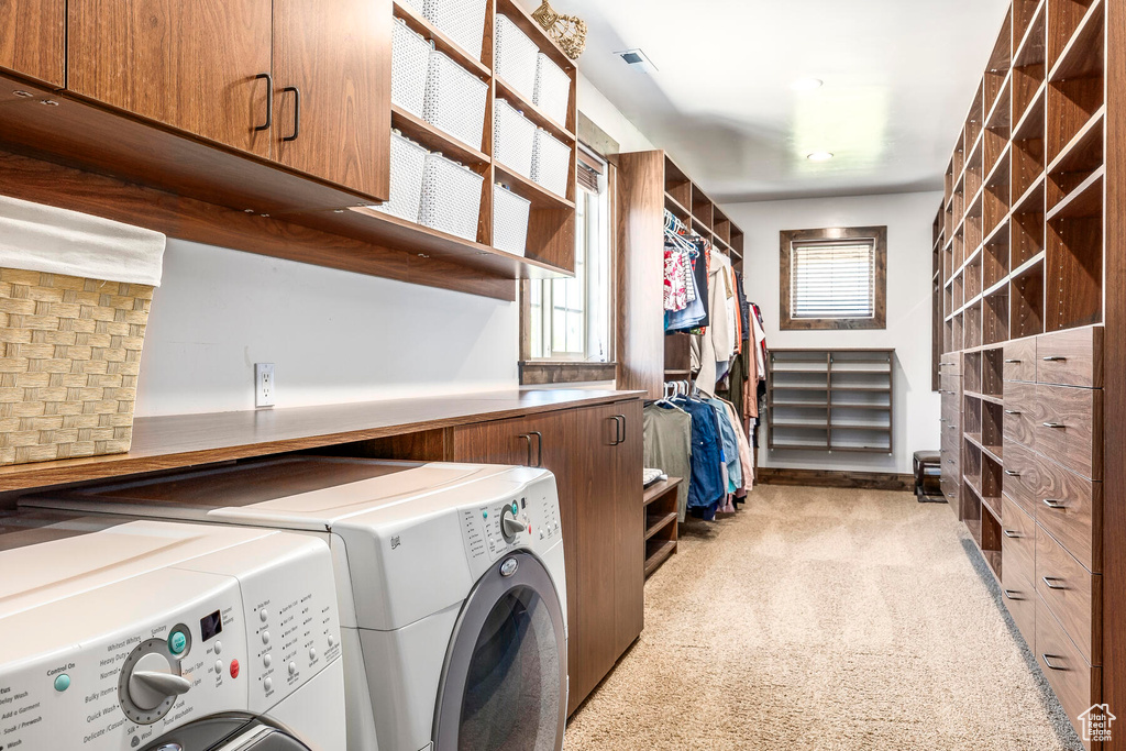 Washroom with washer and clothes dryer and light carpet