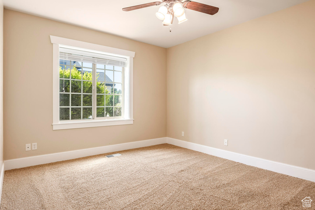 Unfurnished room featuring carpet floors and ceiling fan