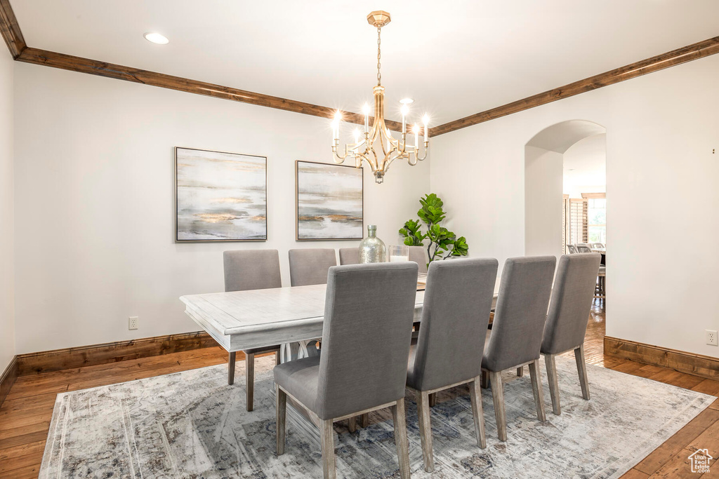 Dining space featuring crown molding, an inviting chandelier, and dark hardwood / wood-style floors