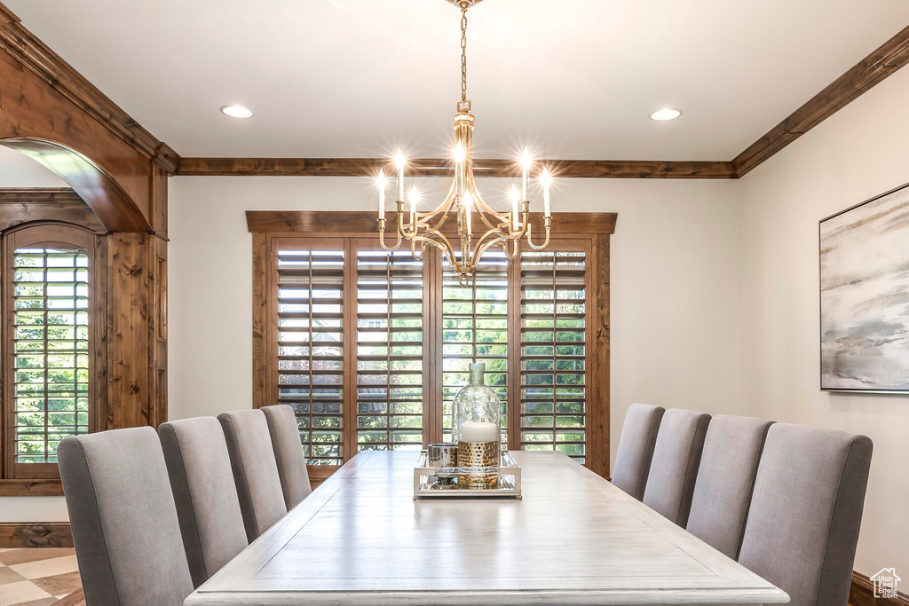 Dining area with an inviting chandelier and ornamental molding