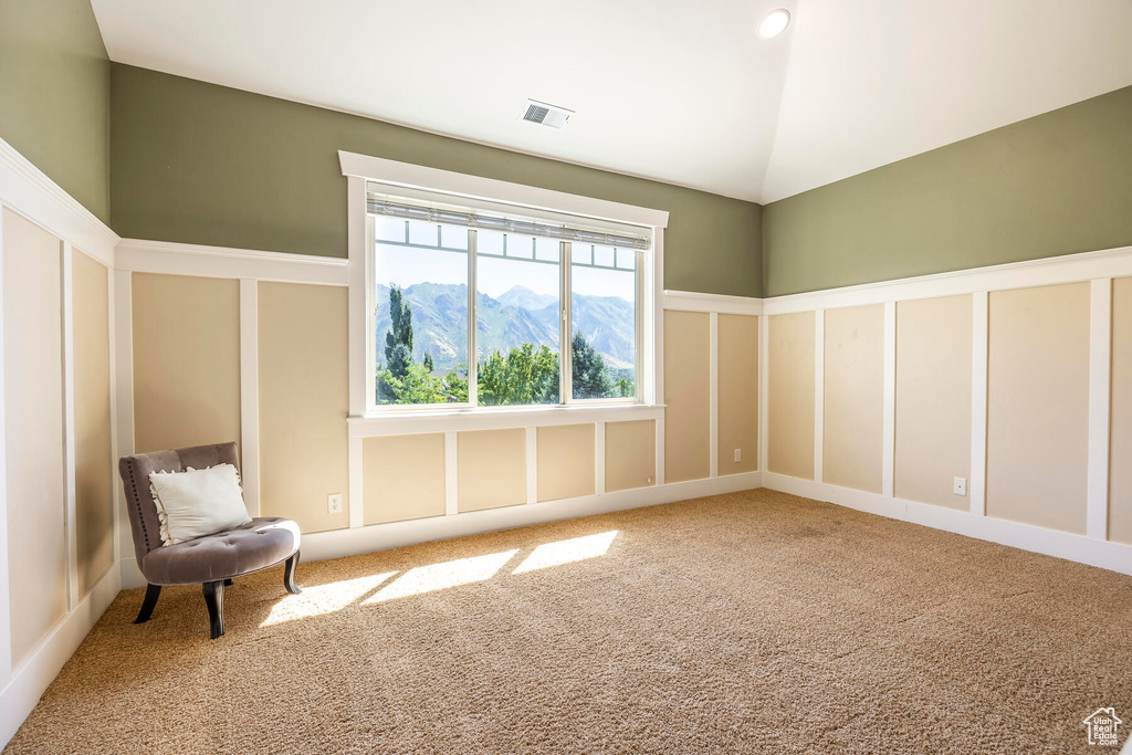 Unfurnished room with carpet floors, a mountain view, and lofted ceiling