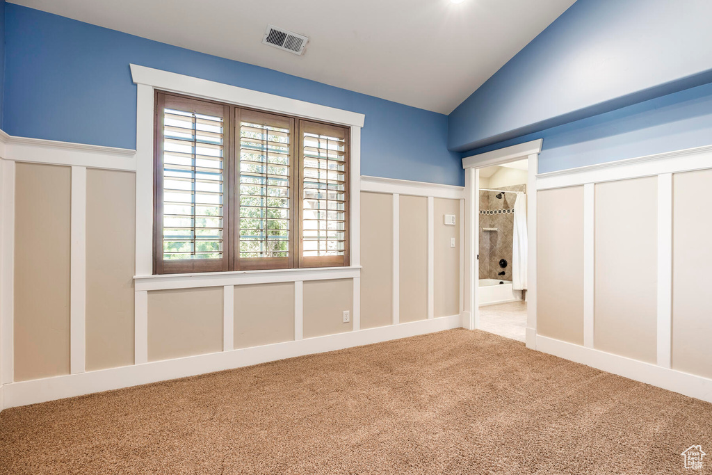 Unfurnished bedroom featuring light colored carpet and lofted ceiling