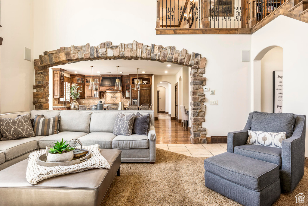 Living room featuring light tile patterned flooring and a high ceiling