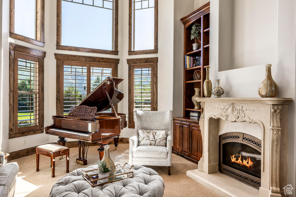 Living area featuring light colored carpet and a high ceiling