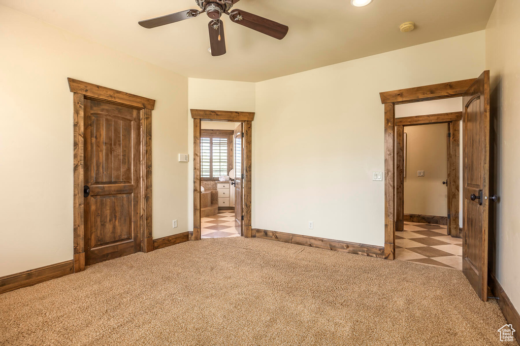 Unfurnished bedroom featuring ceiling fan and light carpet