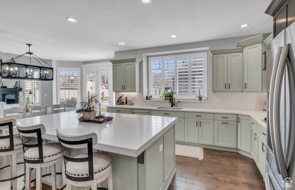 Kitchen with a notable chandelier, backsplash, pendant lighting, and a kitchen bar