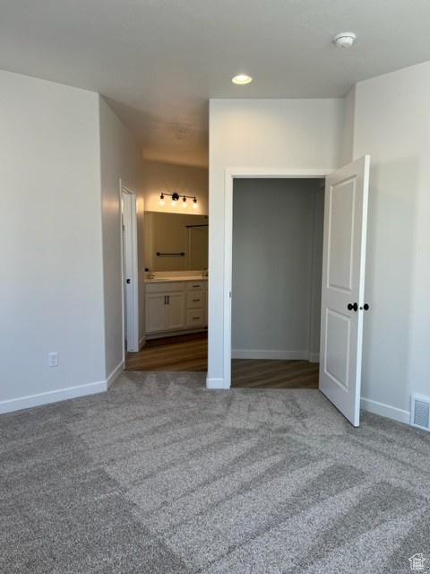 Unfurnished bedroom with light hardwood / wood-style floors and connected bathroom