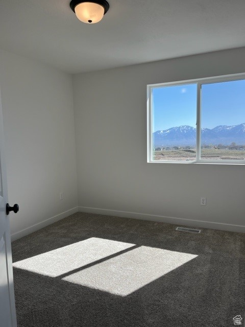 Carpeted spare room featuring a mountain view