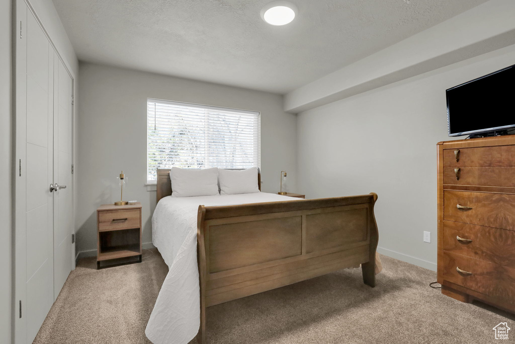 Bedroom with carpet floors and a textured ceiling