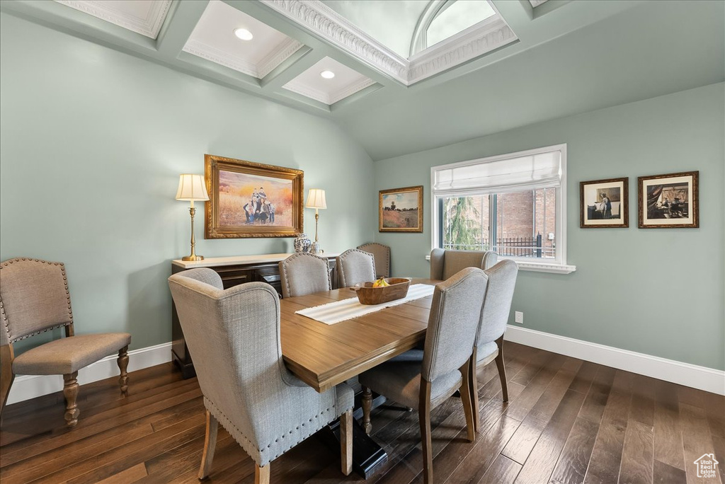 Dining space featuring coffered ceiling, dark hardwood / wood-style floors, and beamed ceiling