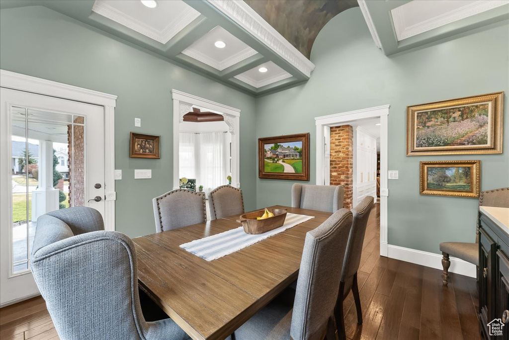 Dining area with coffered ceiling, ornamental molding, beam ceiling, and dark hardwood / wood-style floors