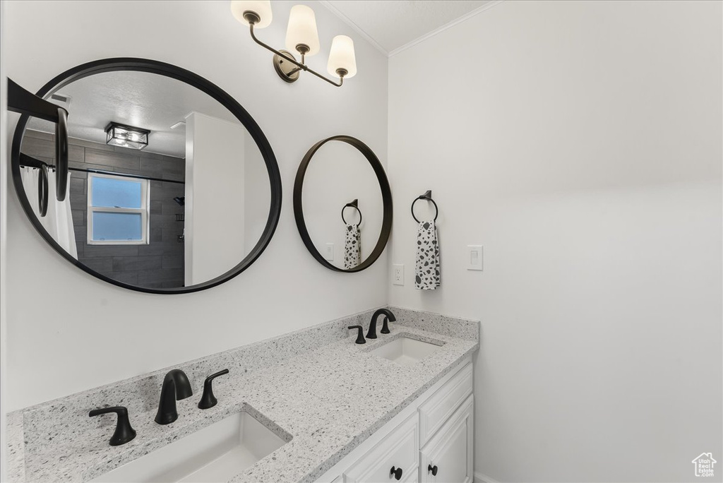 Bathroom featuring dual bowl vanity and ornamental molding